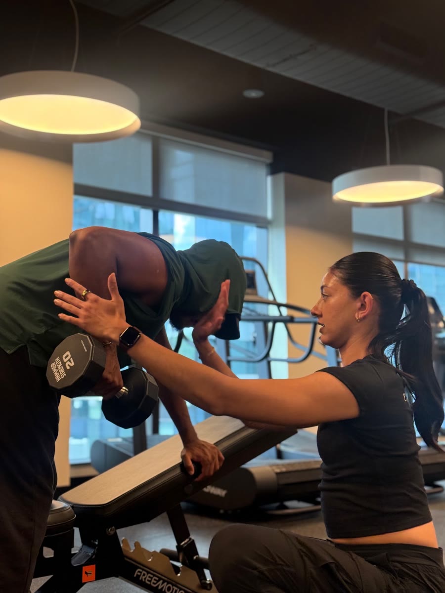 Amrit Kaur cueing a client through a dumbbell row
